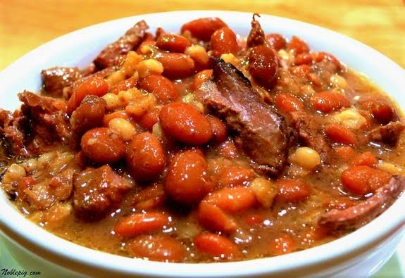 Plato de frijoles rojos con carne y un caldo espeso.