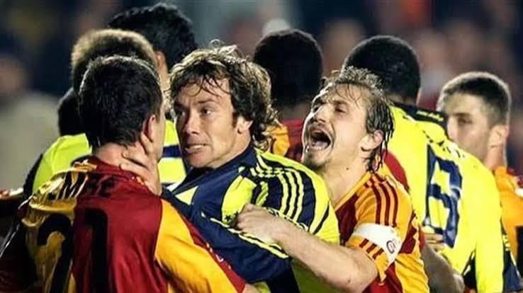 Jugadores de fútbol involucrados en una pelea durante un partido, con expresiones de tensión y enojo.