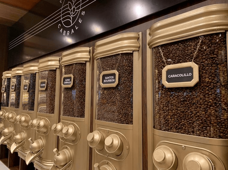 Máquinas dispensadoras de café con diferentes tipos de granos etiquetados, en un ambiente moderno.