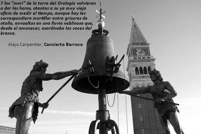 Estatua de dos figuras que tocan una campana en la torre del Orologio, con una Torre inclinada al fondo; imagen en blanco y negro.