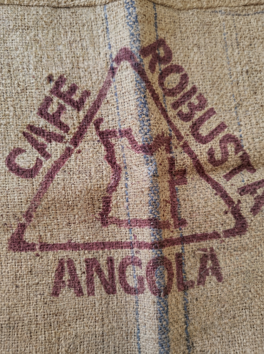 image Saco de café con la etiqueta que dice 'Café Robusta Angola' y un mapa de Angola.