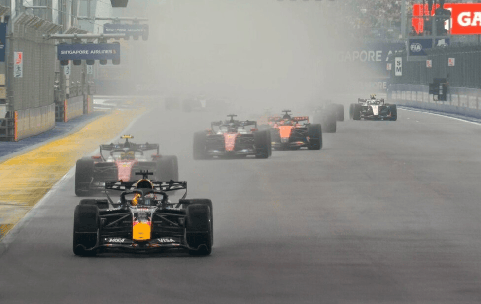 Carrera de Fórmula 1 en Singapur, con varios coches compitiendo en condiciones de baja visibilidad debido a la niebla.