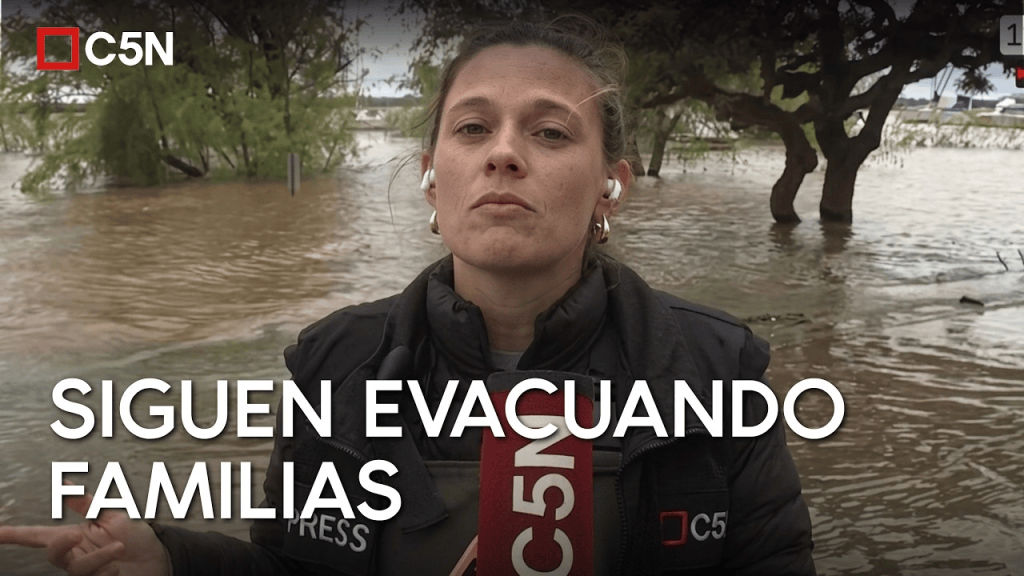 Reportera de C5N informando sobre la evacuación de familias en una zona inundada.