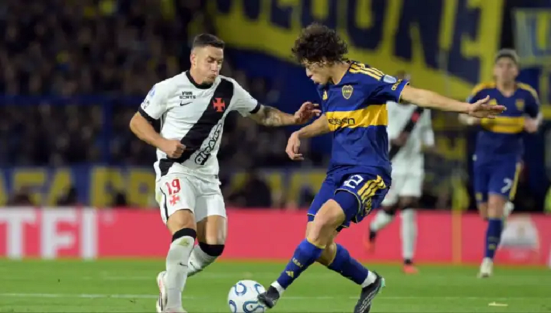 Jugador del Boca Juniors driblando a un oponente del Vasco da Gama durante un partido de fútbol.
