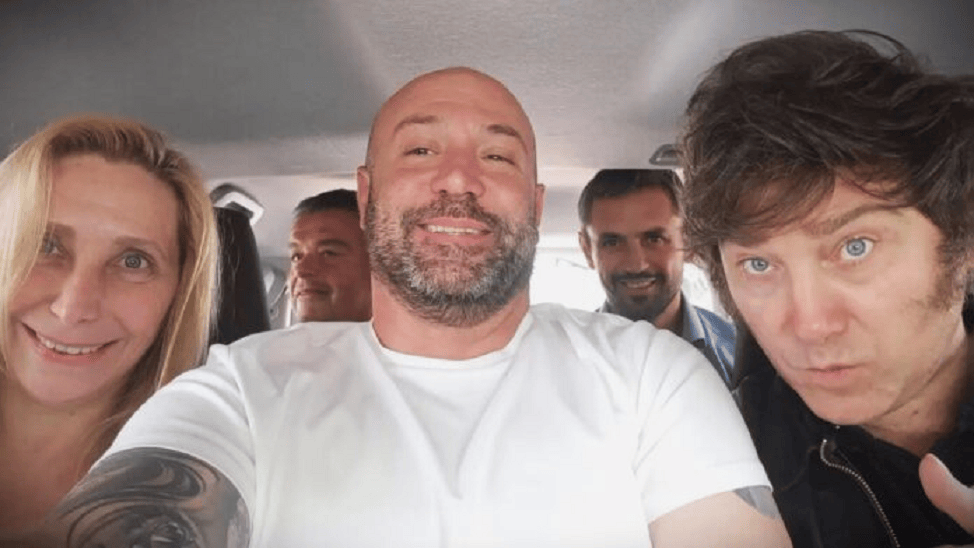 Grupo de cinco personas sonriendo dentro de un automóvil, con un ambiente relajado y amistoso.
