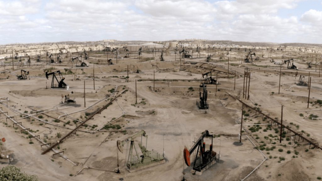 Vista panorámica de un campo petrolero con múltiples bombas de extracción en un terreno árido.