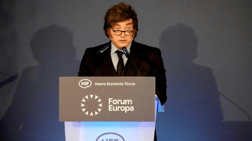 Hombre con cabello rizado y gafas, hablando en un podio con el logo del Fórum Europa durante un evento.
